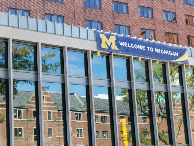 A brick and glass building with a welcome to michigan banner