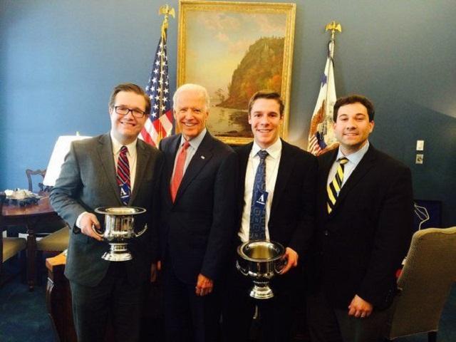 michigan debate team members posing with trophies